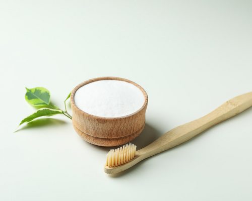 Eco friendly toothbrush and tooth powder on white background